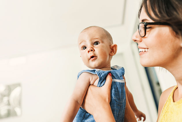 Woman wearing glasses and holding baby